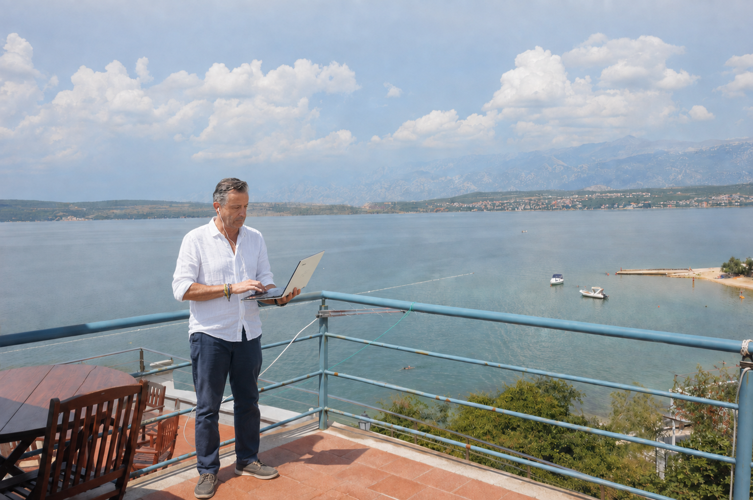 Sergio Maltagliati al computer su una terrazza affacciata sul mare
